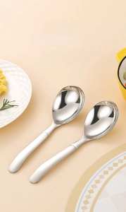 Close-up of two polished 316 stainless steel round spoons with ergonomic long handles