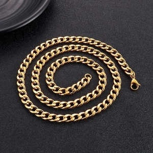 Close-up of golden stainless steel Cuban link chain with lobster clasp on black texture