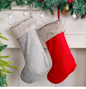 Detail of grey and red Christmas stockings with brown fur trim hanging on fireplace