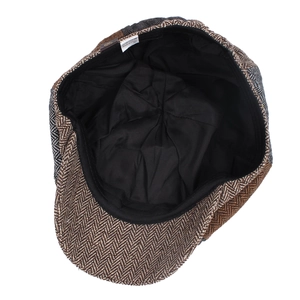 Inside view of a vintage herringbone newsboy cap showing black lining and care label