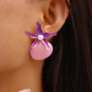 Detail showing shell and starfish earrings with pearl on a model for beach style