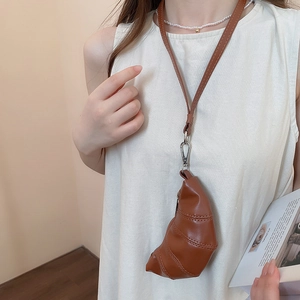 Gros plan sur le sac croissant en cuir PU caramel avec fine bandoulière et crochets