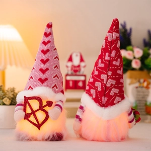 Close-up of lighted Valentine's gnomes with knitted hats and romantic glowing LED hearts