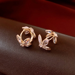 Macro shot of gold floral earrings featuring marquise-cut cubic zirconia in vintage style