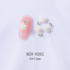 Macro detail of white resin rose and silver crescent moon 3D nail art charms