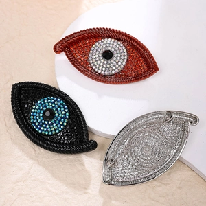 Detailed view of evil eye brooches in red and black crystals with silver pin backing