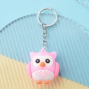Close-up of a cute pink owl keychain pendant with durable silicone and metal ring details