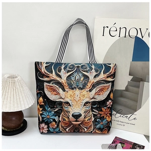 Detailed embroidery of deer and flowers on canvas tote bag with striped straps