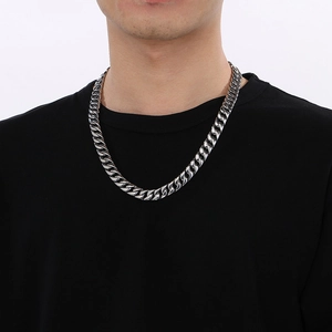 Close-up of 12mm chunky silver stainless steel Cuban link chain necklace on male model