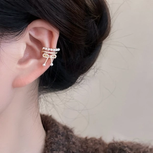 Detail of zircon bow pearl ear cuff with tassel design on female model's ear