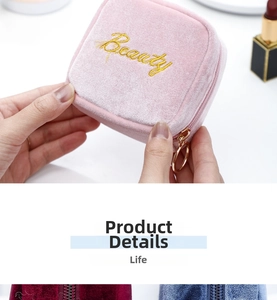 Detail of pink velvet makeup pouch with golden Beauty embroidery and ring zipper puller