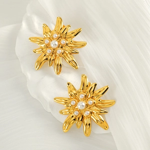 French vintage gold flower earrings with white pearl center on a ceramic plate