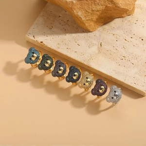 Macro detail of bear-shaped open rings with multi-color zircon stones on stone display