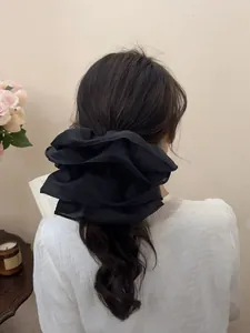 Oversized black double-layered mesh scrunchie shown on a ponytail in a cozy setting