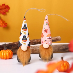 Detail of fall harvest gnome plush with autumn maple leaves and miniature pumpkins