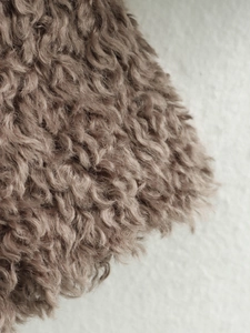 Close-up of curly faux fur texture in coffee brown for a warm French style coat