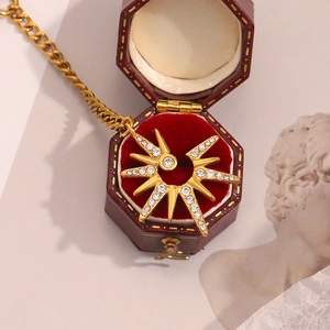 Detail of 18K gold-plated starburst pendant necklace with rhinestones in a vintage box