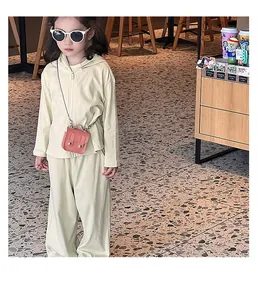 Détail du cardigan à capuche pour enfant et du pantalon large en coton vert clair