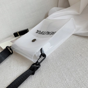 Macro della borsa a tracolla in PVC trasparente con scritta BEAUTIFUL nera su lino