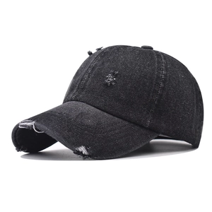 Dettaglio cappello da baseball in denim nero lavato con strappi vintage e cuciture a rilievo