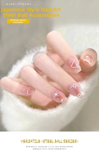 Macro shot of gold caviar beads and pearl flower decorations on elegant white nails
