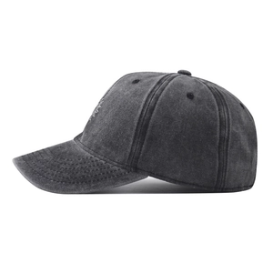 Detail of grey washed cotton baseball cap showing side embroidery and stitched brim