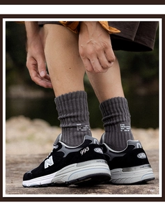 Detail of dark grey cotton crew socks with ribbed cuffs and white letter print on heel