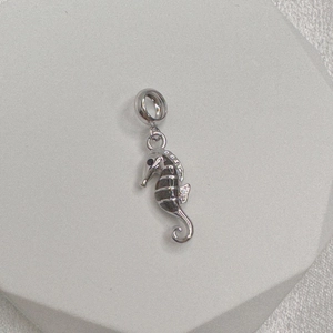 Macro shot of S925 sterling silver seahorse charm with polished finish and hallmark