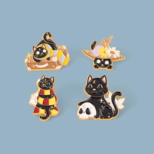 Détail d'un lot de quatre broches en émail chat noir aux thèmes magiques sur fond bleu