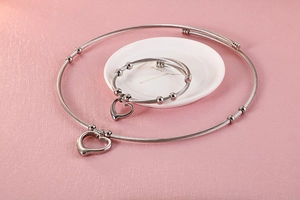 Detailed set of silver cable wire necklace and bracelet with hollow heart pendants