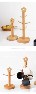Detail of beech wood mug tree rack with floral top and multiple hooks for cup storage