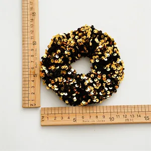 Elastic large sequin hair scrunchie in gold and black showing 11cm diameter size detail
