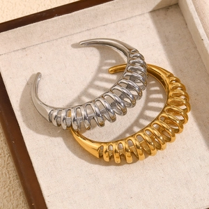 Detail view of 18K gold and silver plated stainless steel wavy spiral cuff bracelets