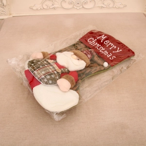 Detail of red and green Christmas stocking with 3D Santa plush and Merry Christmas embroidery