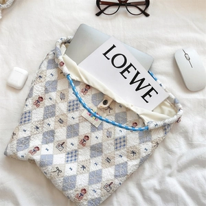 Detail of quilted bear laptop sleeve with diamond stitching and soft blue accents