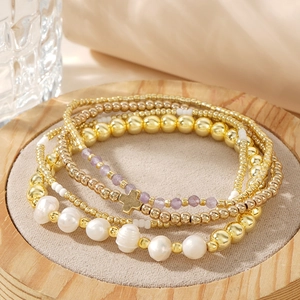 Four-piece multilayer beaded bracelet set with gold cross charm and purple faceted beads
