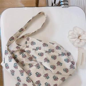 Detailed close-up of floral cotton tote bag with purple flower patterns on a white seat