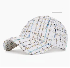 Close-up of off-white tweed baseball cap with light blue and gold woven textures