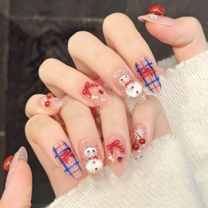 Christmas press-on nails featuring snowman, plaid bows, and pearls on pink glossy base