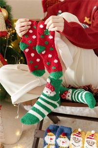 Close-up of festive coral fleece Christmas socks with colorful patterns and soft texture