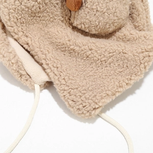 Dettaglio del cappello in pile beige con morbidi lacci e graziose orecchie da orso