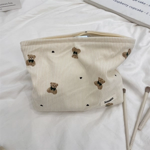 Detailed texture of corduroy makeup bag with cute bear embroidery and heart pattern
