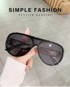 Macro detail of large aviator style sunglasses with classic black frame and dark grey lenses