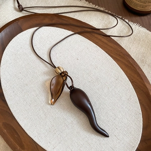 Detail of vintage resin pendant with wood elements on a textured rustic linen background