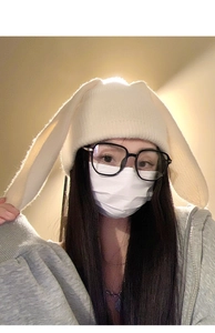 Close-up of fluffy white knitted rabbit ear beanie showing soft wool texture and cute design