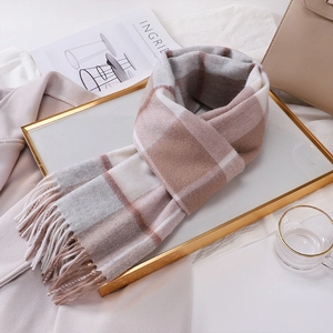 Flat lay of brown and beige wool plaid scarf with fringes and lifestyle props
