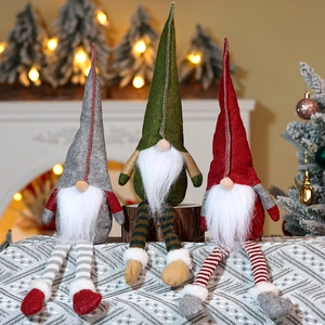 Three long-legged Christmas gnomes in grey red and green sitting on a cozy surface