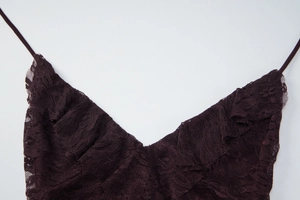 Détails de la dentelle violet foncé et des fines bretelles du col en V de la robe