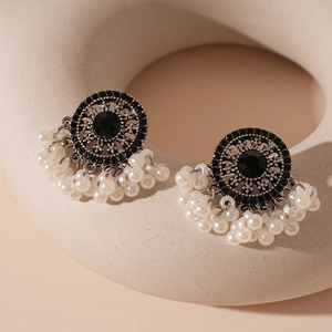 Detail of vintage round rhinestone stud earrings with multi-row white pearl tassels
