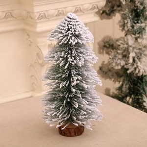 Close-up of mini cedar Christmas tree with snow-flocked needles on a wooden base